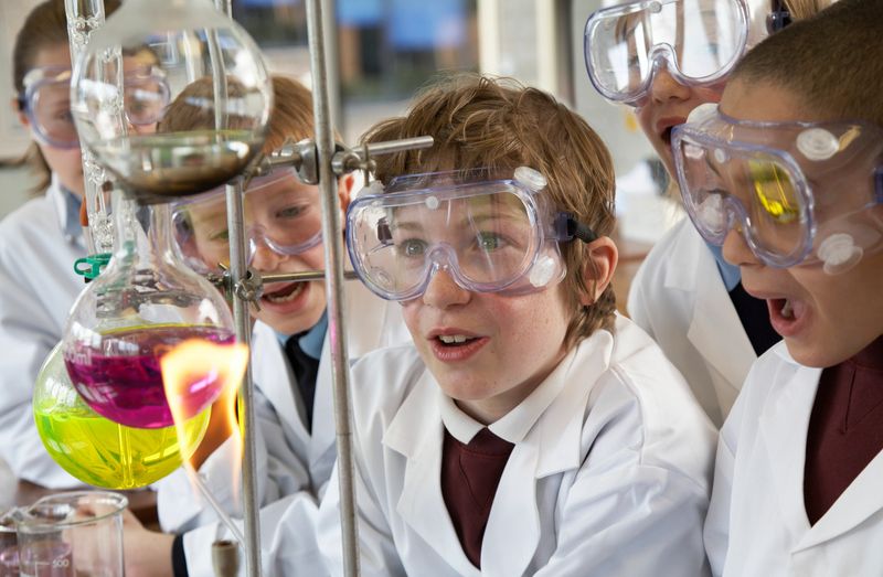 Group of children (9-12) watching experiment in school laboratory