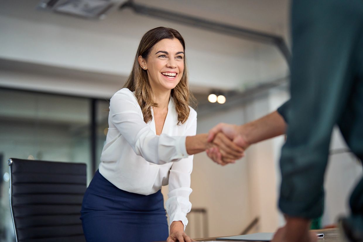 Happy woman shaking hands in a business setting.