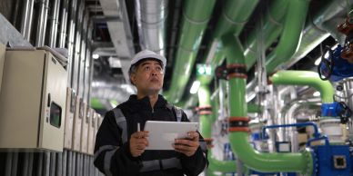 Engineer inspecting pipes in an industrial facility.