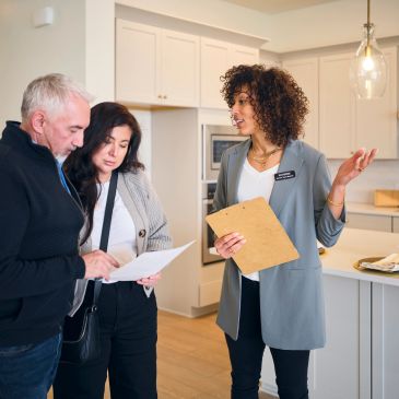 Agente inmobiliaria mostrando casa a pareja.