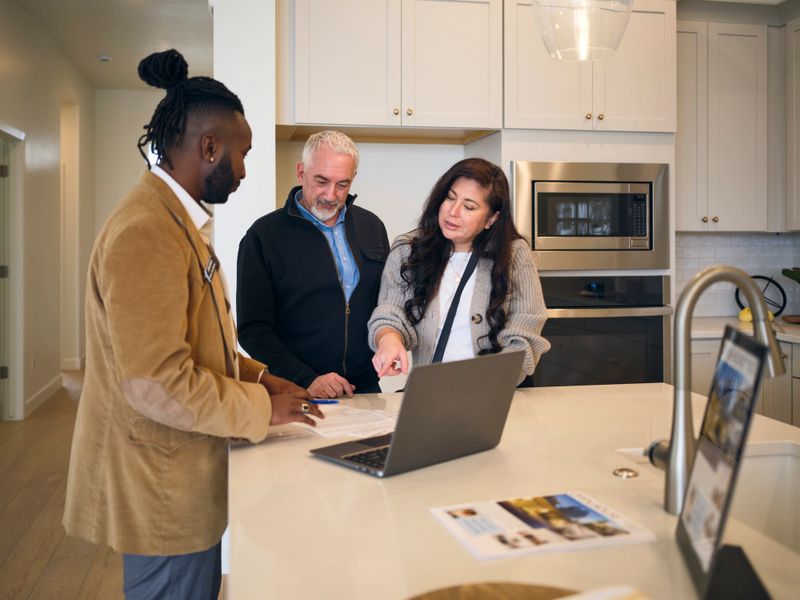A professional real estate agent, showing a new home to prospective buyers.