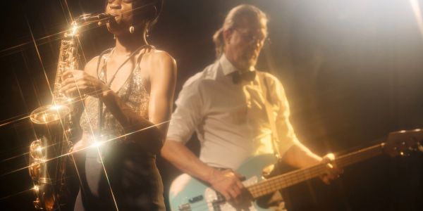 Two musicians playing saxophone and guitar on stage.