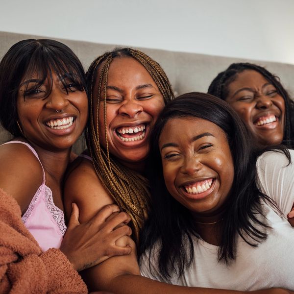 Four friends laughing together joyfully.