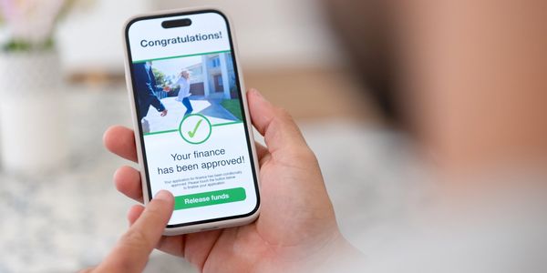 Person viewing approved finance notification on smartphone screen.
