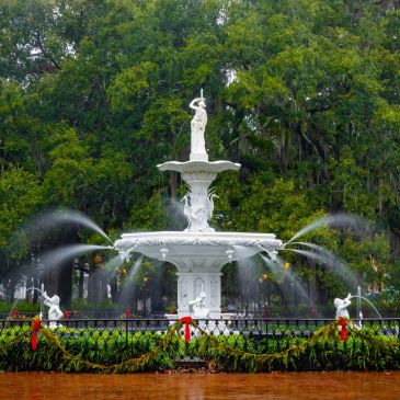 Decorative white fountain with water jets in a park.