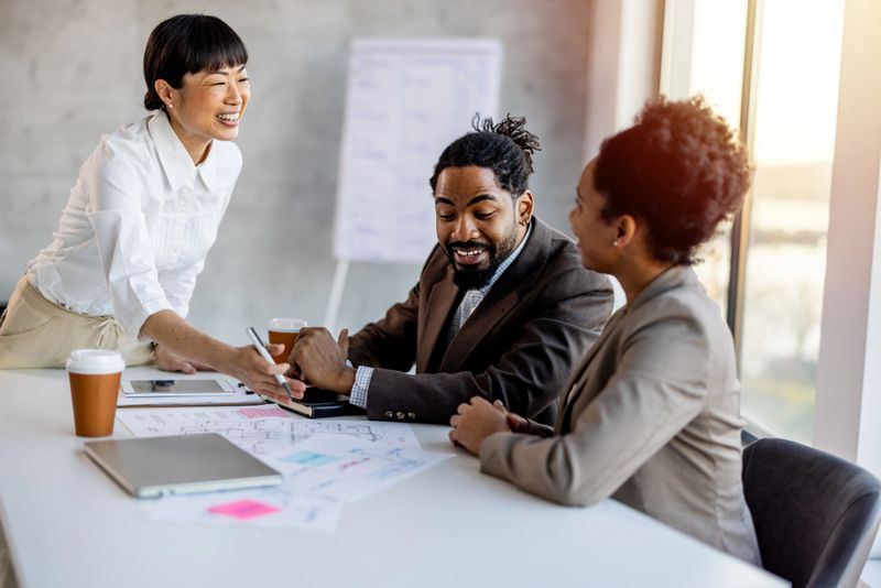 Multi racial diverse group of people working with Paperwork on a board room table at a business presentation or seminar.