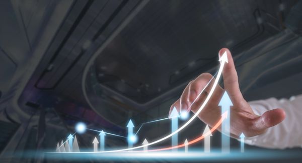 Hand interacting with upward growth chart on digital screen.