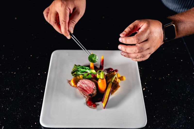 Chef is finishing the plate. Decorating the plate just before the serving.