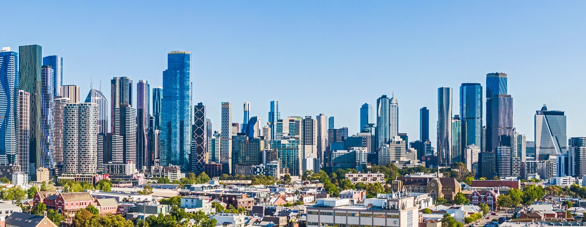 Panoramic view of a modern city skyline under clear blue sky.
