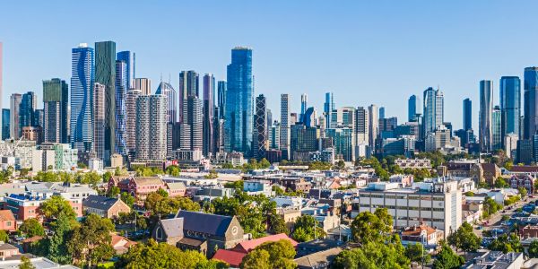 Sunny day with a city skyline and residential buildings.