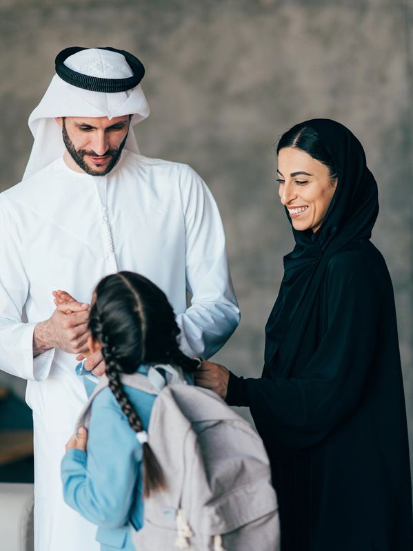 Middle Eastern parents happily send their daughter to school.