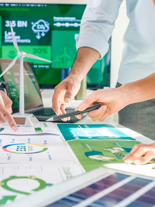 Team reviewing ESG and sustainability reports with wind turbine model.