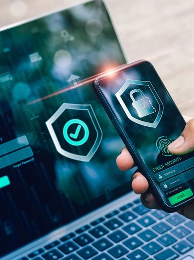 Smartphone and laptop showing cybersecurity icons.