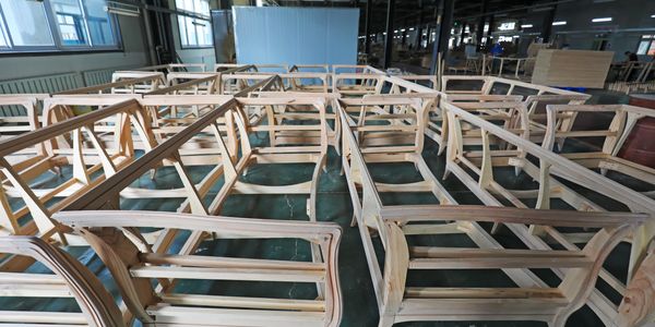 Wooden sofa frames lined up in a furniture workshop.