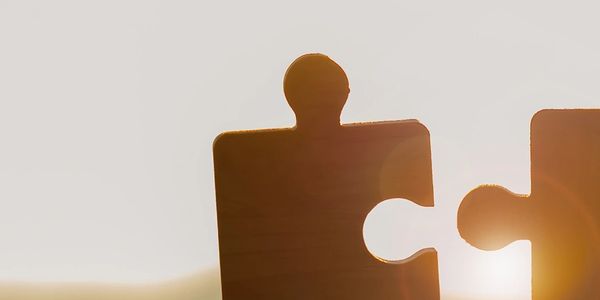 Two puzzle pieces about to interlock held against light showing seamless medical billing solutions. 