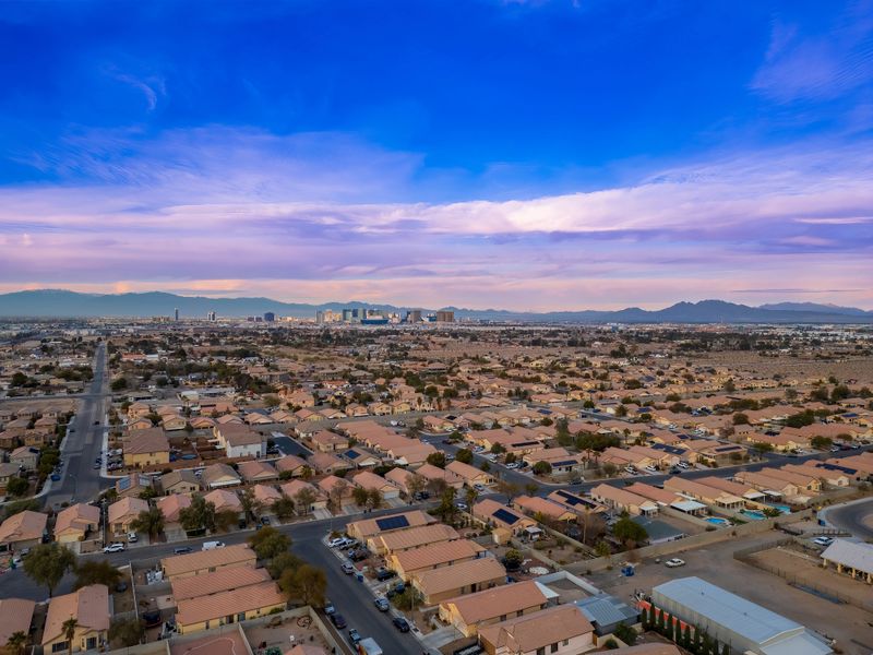 A twilight view of Las Vegas neighborhood with uniform homes, leading to the iconic Strip