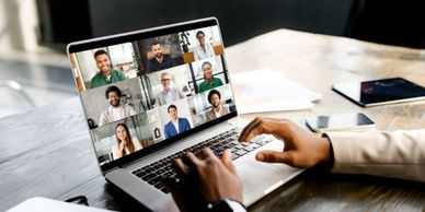 Person participating in a virtual video conference on a laptop.