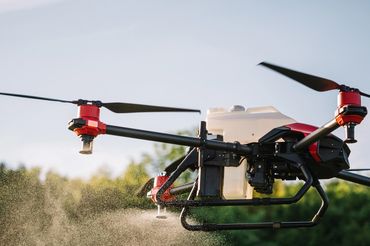 Agricultural drone spraying crops with precision in a field.