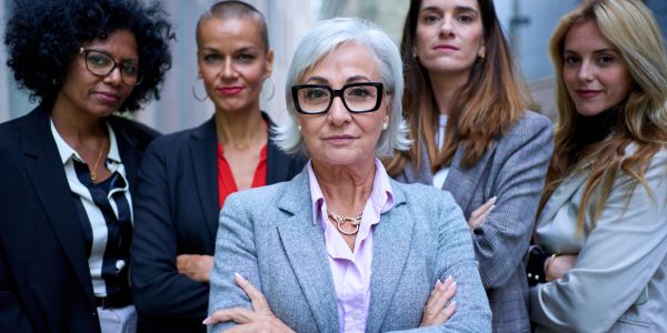 Confident group of five professional women posing together.