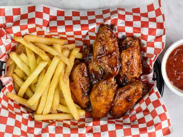 Crispy fries and glazed chicken wings served with dipping sauce.