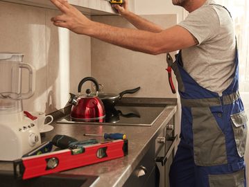 Technician fixing interior wall damage, representing expert indoor home repair services.