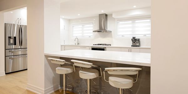 Modern white kitchen with island and bar stools.