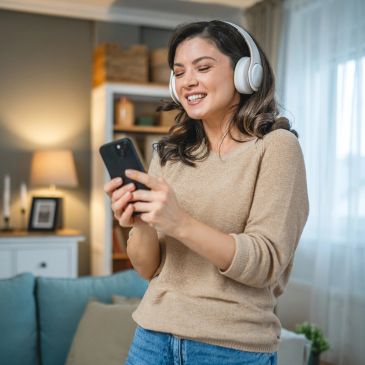 Woman enjoying music with headphones and phone.