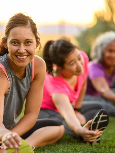 Women stretching together outdoors.