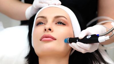 Woman receiving a facial treatment with a laser device.
