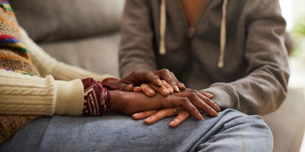 Two people holding hands in a comforting gesture.