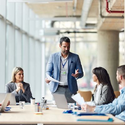 Business meeting with a man presenting to colleagues in a modern office.