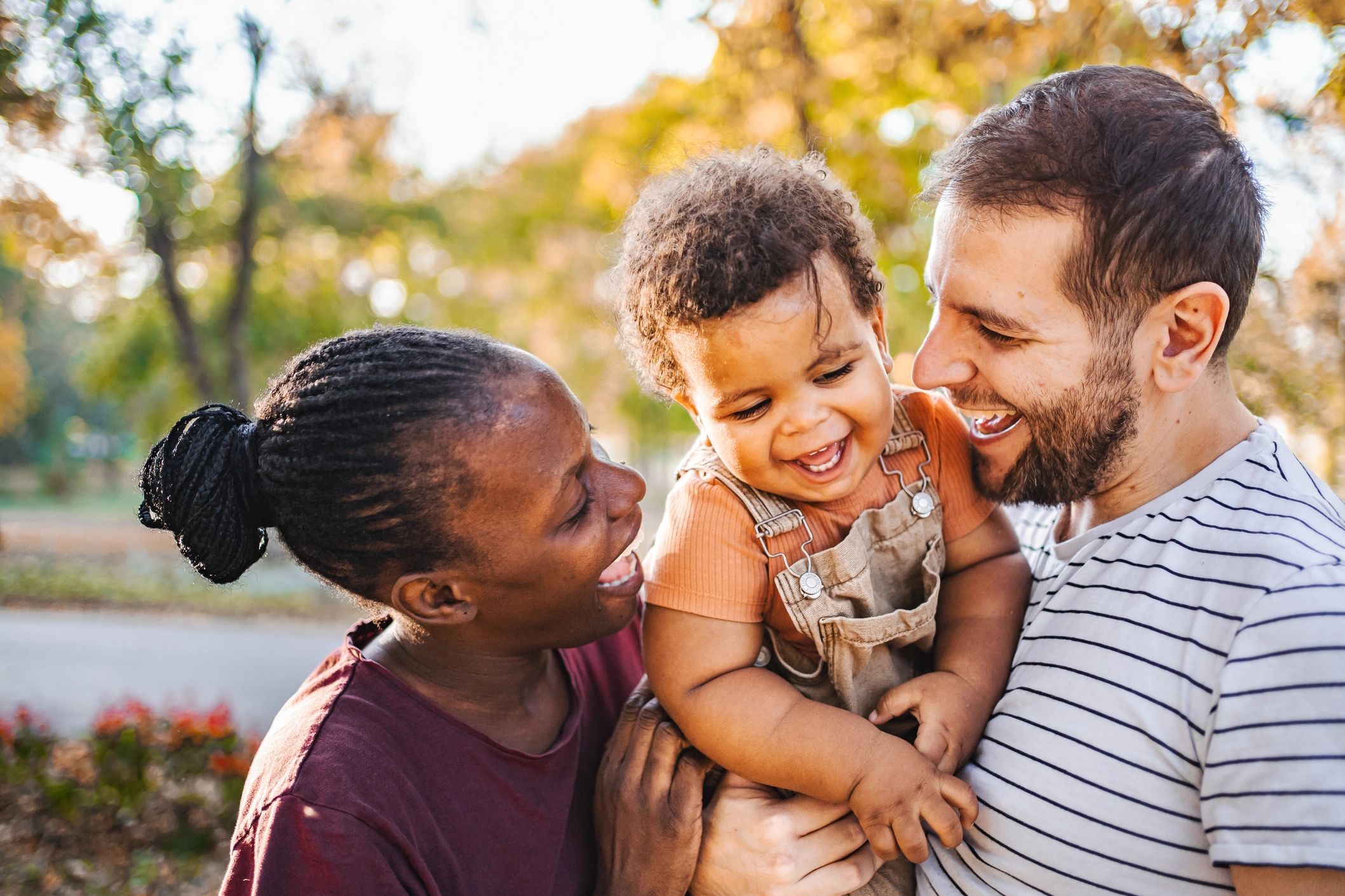 Happy family enjoying time together outdoors with their smiling child.