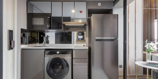 Modern kitchenette with appliances and a washing machine.