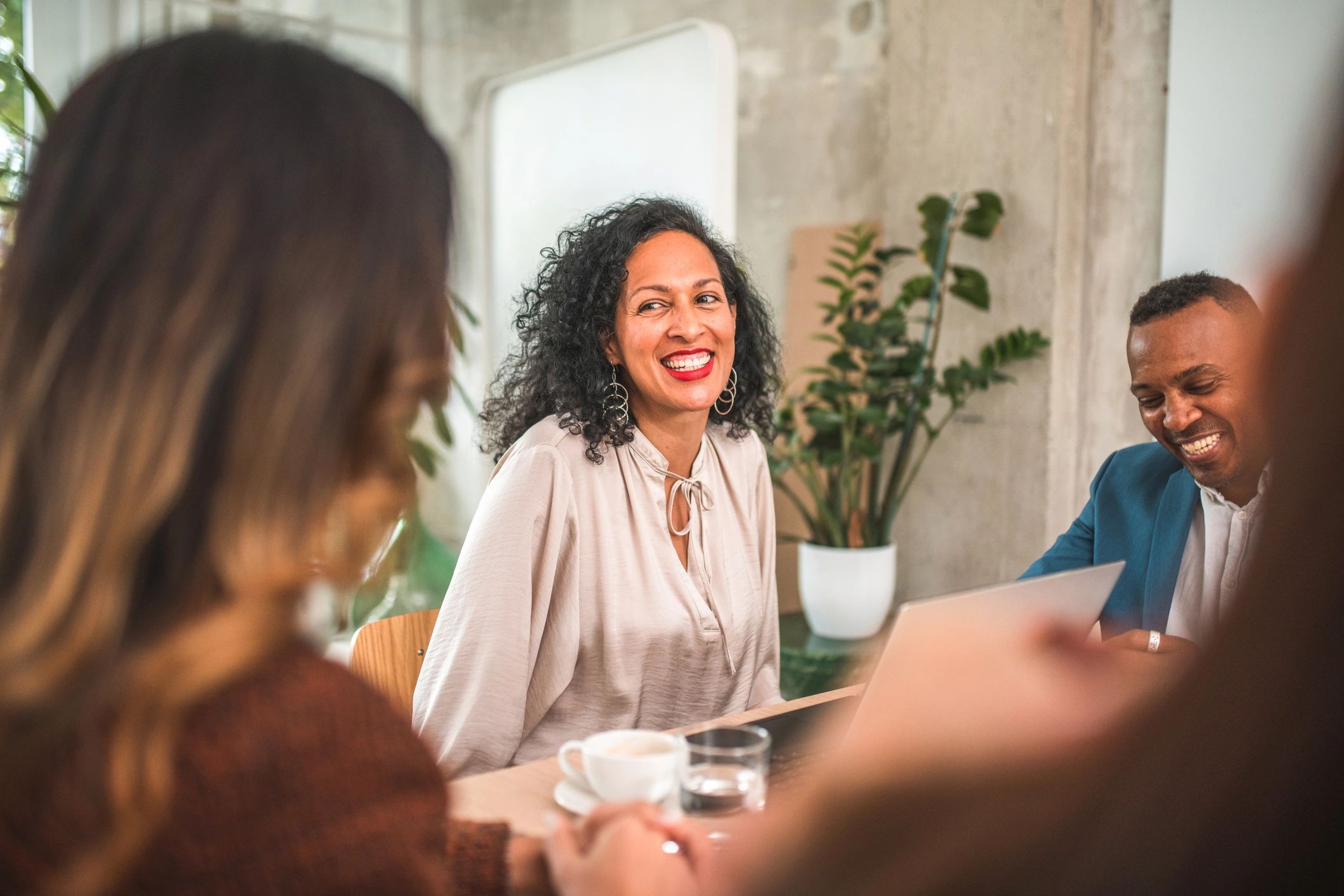 three business people in a meeting and smiling
