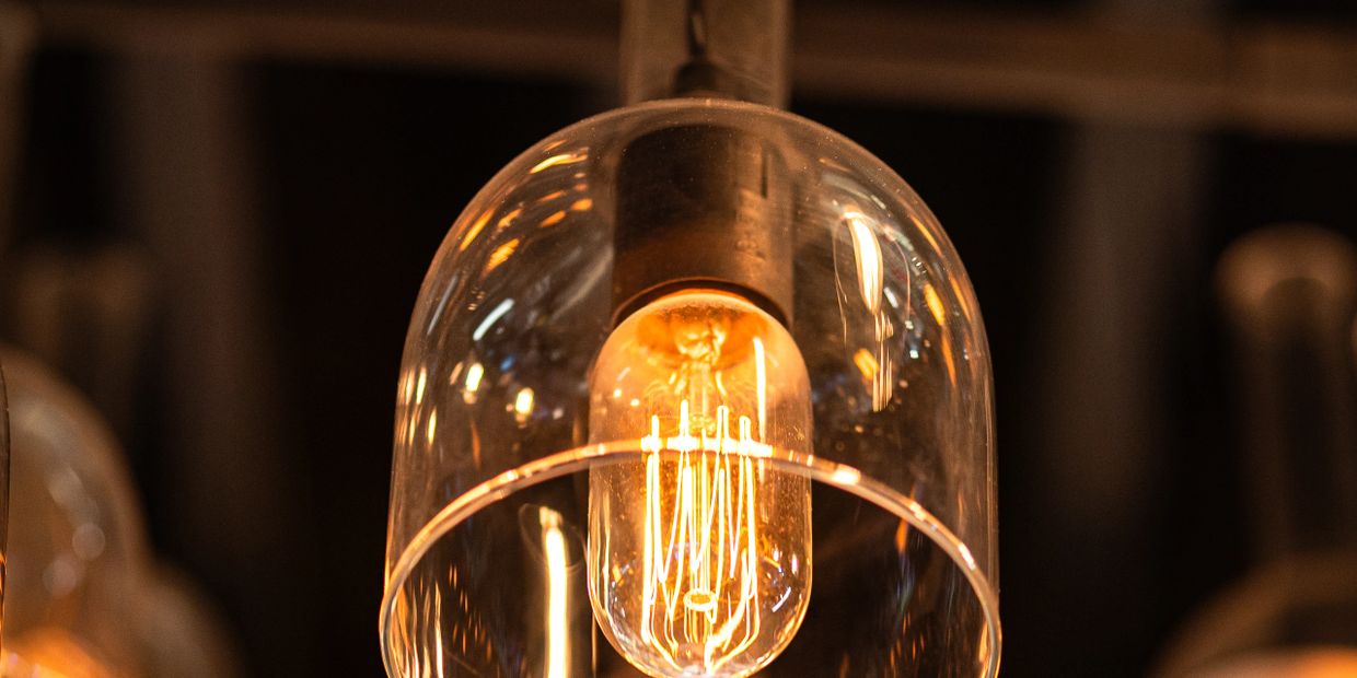 Close-up of a glowing vintage filament light bulb with a glass cover.