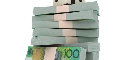 Stacks of money with a small house model on top.