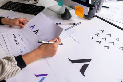 A young artist draws an upside-down cartoon character at a colorful art table.