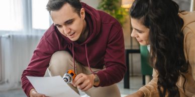 Two people assembling furniture with instructions.