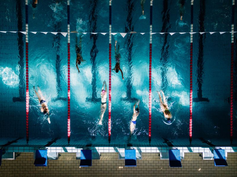 Aerial Top Down View Swimmers Swimming in outdoor olympic-size 50m Swimming Pool. Professional training.
