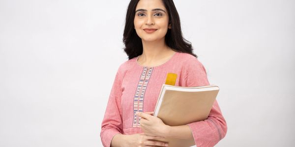 Smiling woman in a pink kurta holding a folder with documents.