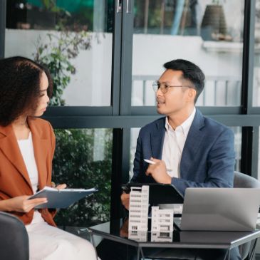Two professionals discussing real estate models.