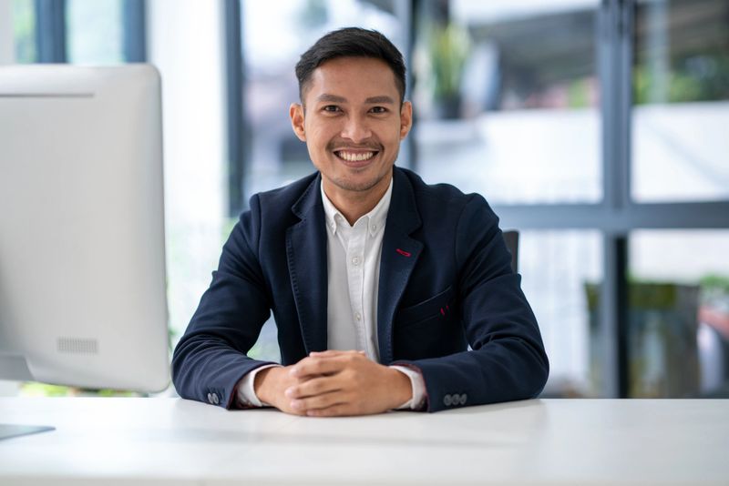 Portrait of office man in confidence smiling while sit on desk office