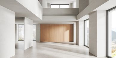 Bright empty modern room with large windows and wooden accent wall.