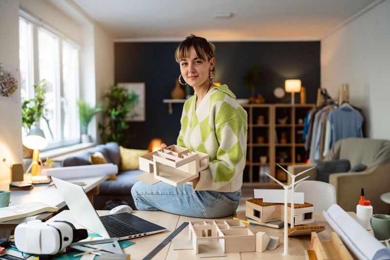 Portrait of a female architecture student making architectural model of a modern house.
