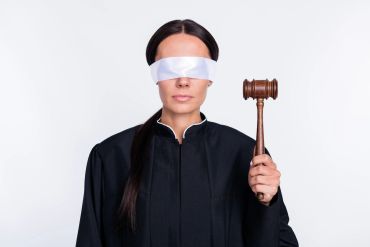 Blindfolded judge holding a gavel.