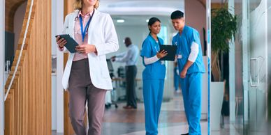 Medical professionals in a hospital hallway reviewing patient information.