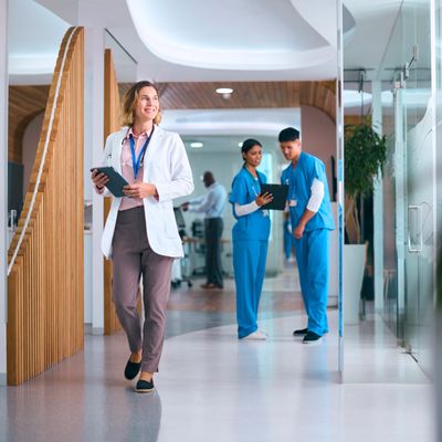 A doctor and two nurses in a modern hospital hallway.