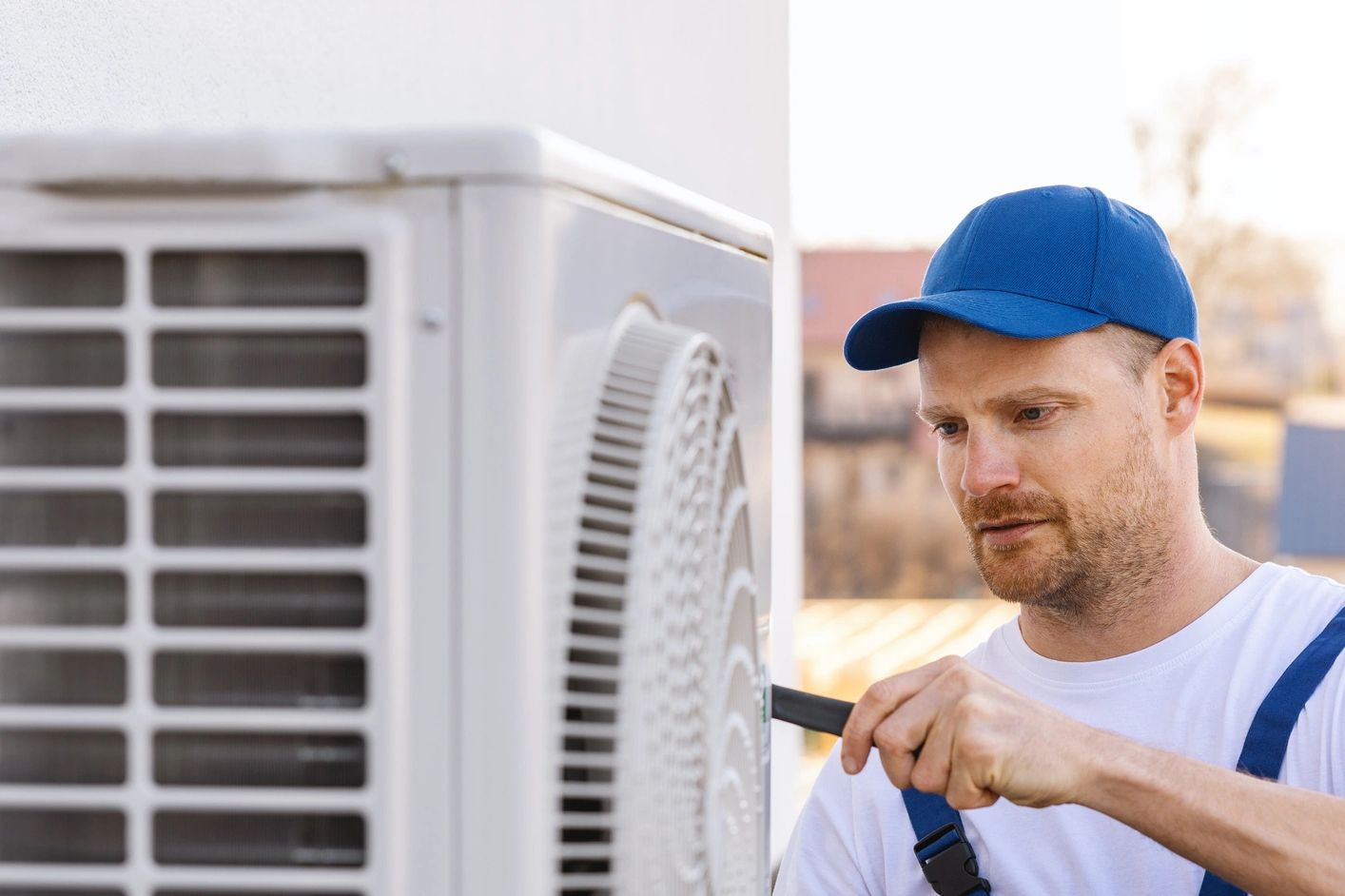 Technician repairing an outdoor air conditioning unit.