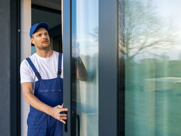 Man installing a glass door.