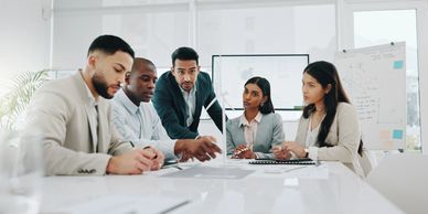 Three men and 2 women meeting and discussing a project.